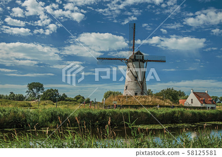 Old windmill next to canal with bushes and grove near Damme Old windmill next to canal with bushes and grove near Damme 58125581