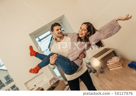 Young couple being happy buying a new house 58127876