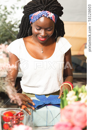 Attractive brunette female person looking at gift box Attractive brunette female person looking at gift box 58128603