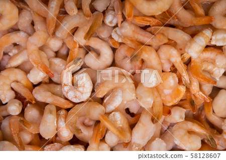 Pile of uncooked, lightly frozen shrimps and prawns. Orange seafood texture, background, top view. Pile of uncooked, lightly frozen shrimps and prawns. Orange seafood texture, background, top view. 58128607