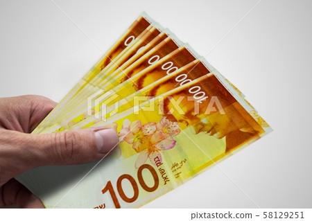 Hand holding Israeli shekels. ILS. Money of 58129251