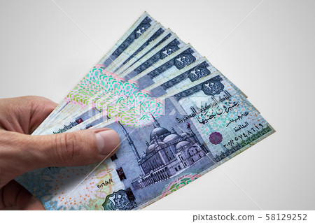Hand holding Egyptian Pounds. EGP. Currency of 58129252