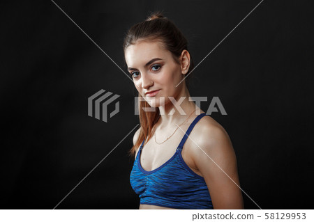A portrait of caucasian girl with ponytail hairstyle in blue fitness top A portrait of caucasian girl with ponytail hairstyle in blue fitness top 58129953