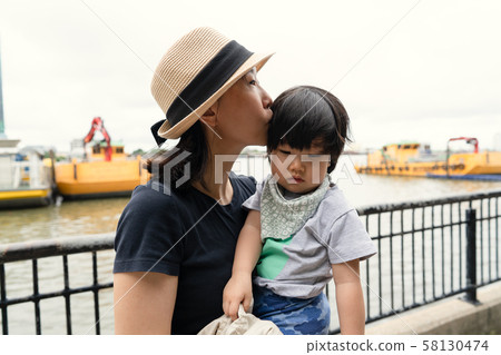 Asian mother kissing her toddler child Asian mother kissing her toddler child 58130474