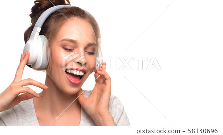 Attractive girl singing with headphones on white background 58130696
