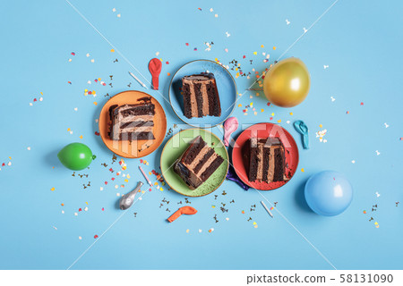 Chocolate cake slices on colorful plates and party 58131090