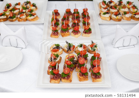 Delicious canape with sausage and tomato.Canapes 58131494