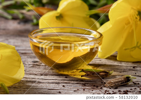 Evening primrose oil, seeds and flowers on a table 58132010