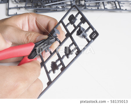 Male hand making a plastic model Male hand making a plastic model 58135013