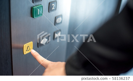 Male hand pressing on emergency button in elevator Male hand pressing on emergency button in elevator 58136237
