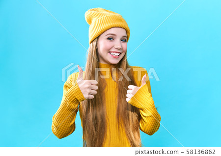 Happy excited woman smile holding thumbs up gesture, beautiful young woman smile looking at camera Happy excited woman smile holding thumbs up gesture, beautiful young woman smile looking at camera 58136862
