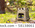 Folding wood stove designed for cooking outdoors using twigs as fuel on nature background 58138661