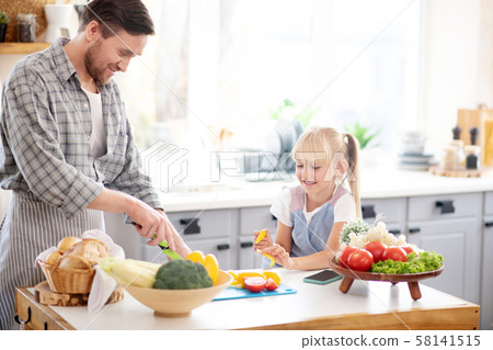 Daughter watching daddy cooking lunch for family 58141515