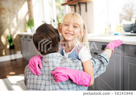 Beaming daughter hugging daddy after cleaning kitchen 58141949