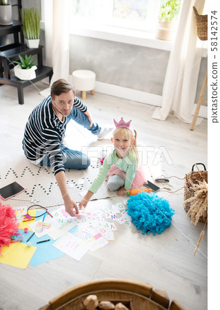 Beaming girl in little crown feeling happy playing with daddy Beaming girl in little crown feeling happy playing with daddy 58142574