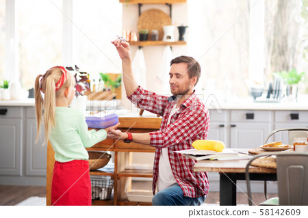 Loving daddy giving lunch box to his schoolgirl 58142609