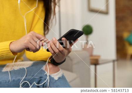 Young woman at home using a smartphone Young woman at home using a smartphone 58143713