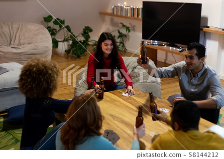 Millennial adult friends socialising together at home 58144212