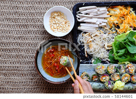 Top view people eating vegetarian rice paper rolls with sauce Top view people eating vegetarian rice paper rolls with sauce 58144601