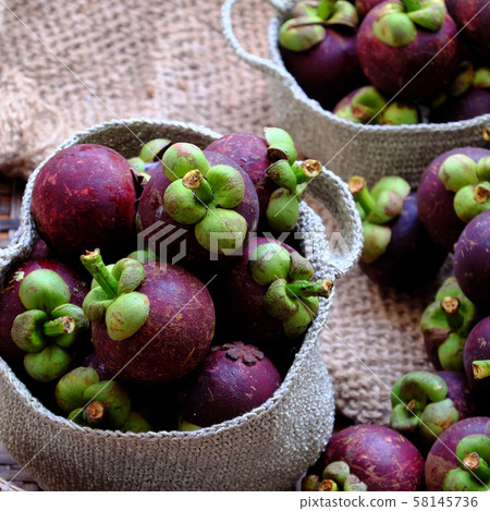 Close up fresh Mangosteens fruit in handbag on burlap background Close up fresh Mangosteens fruit in handbag on burlap background 58145736