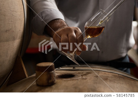 wooden barrel on a dark background, in a workshop 58145785