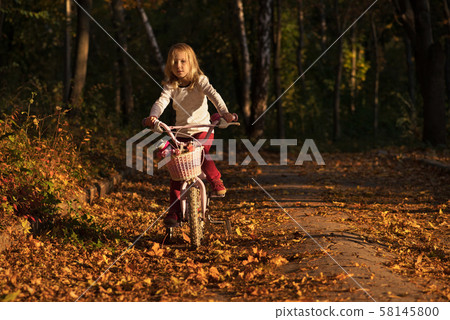 portrait of little girl riding a bicycle 58145800