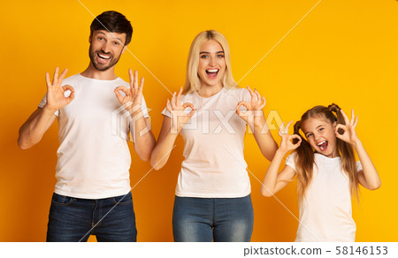 Cheerful Family Gesturing Okay Standing Over Yellow Background, Studio Shot 58146153