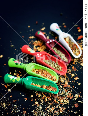 Spices and wooden spoons on black 58146343