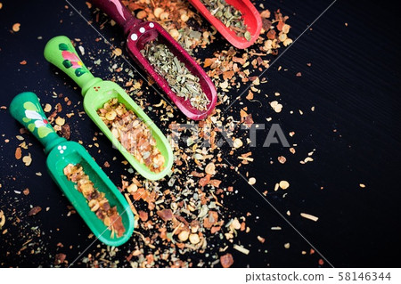 Spices and wooden spoons on black Spices and wooden spoons on black 58146344