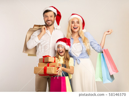 Family In Santa Hats Holding Gifts And Shopping Bags, Studio 58146370
