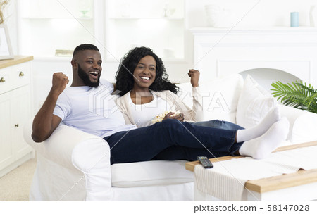Black Millennial Couple Watching Sports On Television And Cheering 58147028