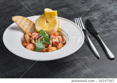 pasta with shrimp and fish on a dark background. pasta with shrimp and fish on a dark background. 58147567