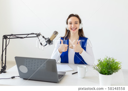 Radio, blogging, broadcast concept - Young woman working on the radio and showing thumbs up Radio, blogging, broadcast concept - Young woman working on the radio and showing thumbs up 58148558