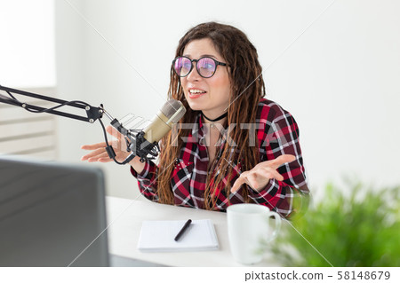 Broadcast, music, dj and people concept - woman with dreadlocks and glasses working at the radio 58148679