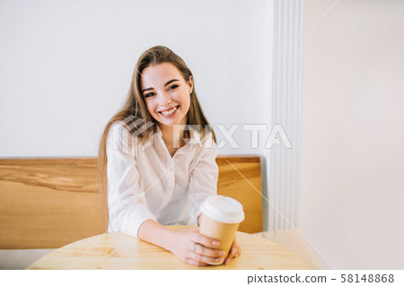 Happy young woman in a cafe with a cup of coffee. Happy young woman in a cafe with a cup of coffee. 58148868