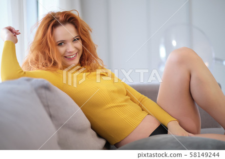 Portrait of a red-haired girl in a yellow sweater Portrait of a red-haired girl in a yellow sweater 58149244