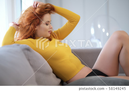 Portrait of a red-haired girl in a yellow sweater 58149245