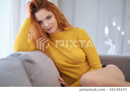 Portrait of a red-haired girl in a yellow sweater Portrait of a red-haired girl in a yellow sweater 58149247