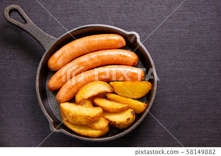 Wiener sausage and french fries (with skin) assorted in skillet. Wiener sausage and french fries (with skin) assorted in skillet. 58149882