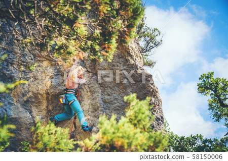 Girl climbing a rock. Girl climbing a rock. 58150006
