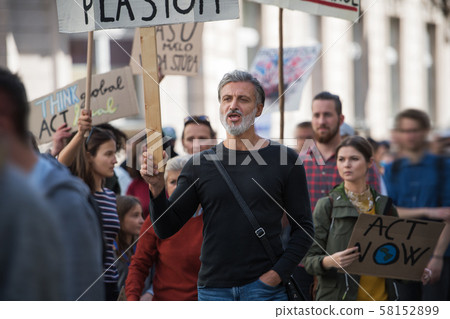 People with placards and protective suit on global strike for climate change. 58152899