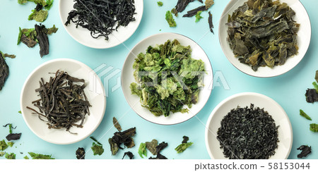 A panorama of various dry seaweed, sea vegetables, shot from the top on a teal blue background 58153044
