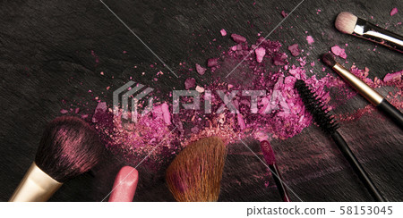 A panorama of makeup brushes and lipstick with crushed cosmetics, shot from the top on a dark A panorama of makeup brushes and lipstick with crushed cosmetics, shot from the top on a dark 58153045
