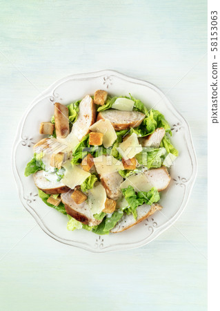Chicken Caesar salad. Slices of chicken breast, green lettuce, Parmesan cheese, and croutons, shot 58153063
