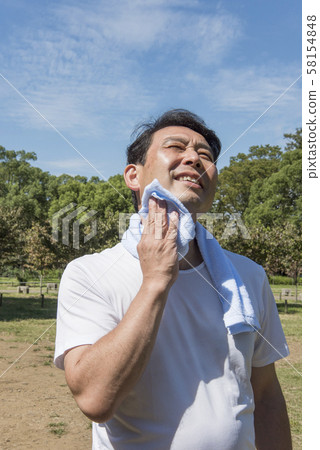 Mature man wiping sweat after exercising in Yoyogi Park 58154848
