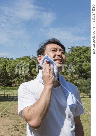 Mature man wiping sweat after exercising in Yoyogi Park 58154850