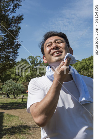 Mature man wiping sweat after exercising in Yoyogi Park 58154859