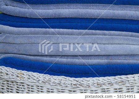 Stack of blue towels in white basket 58154951
