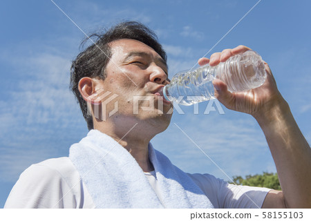 代代木公園運動對抗中暑後的中年男子飲用水 58155103
