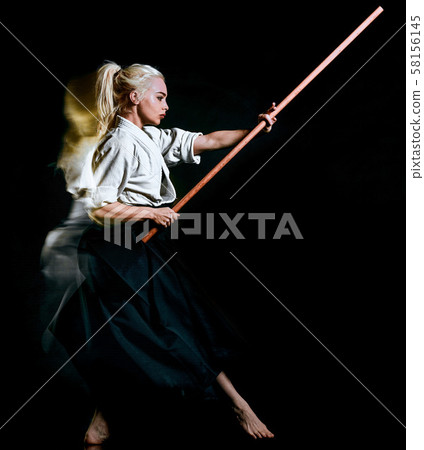 Bo-Jutsu budoka woman isolated black background 58156145